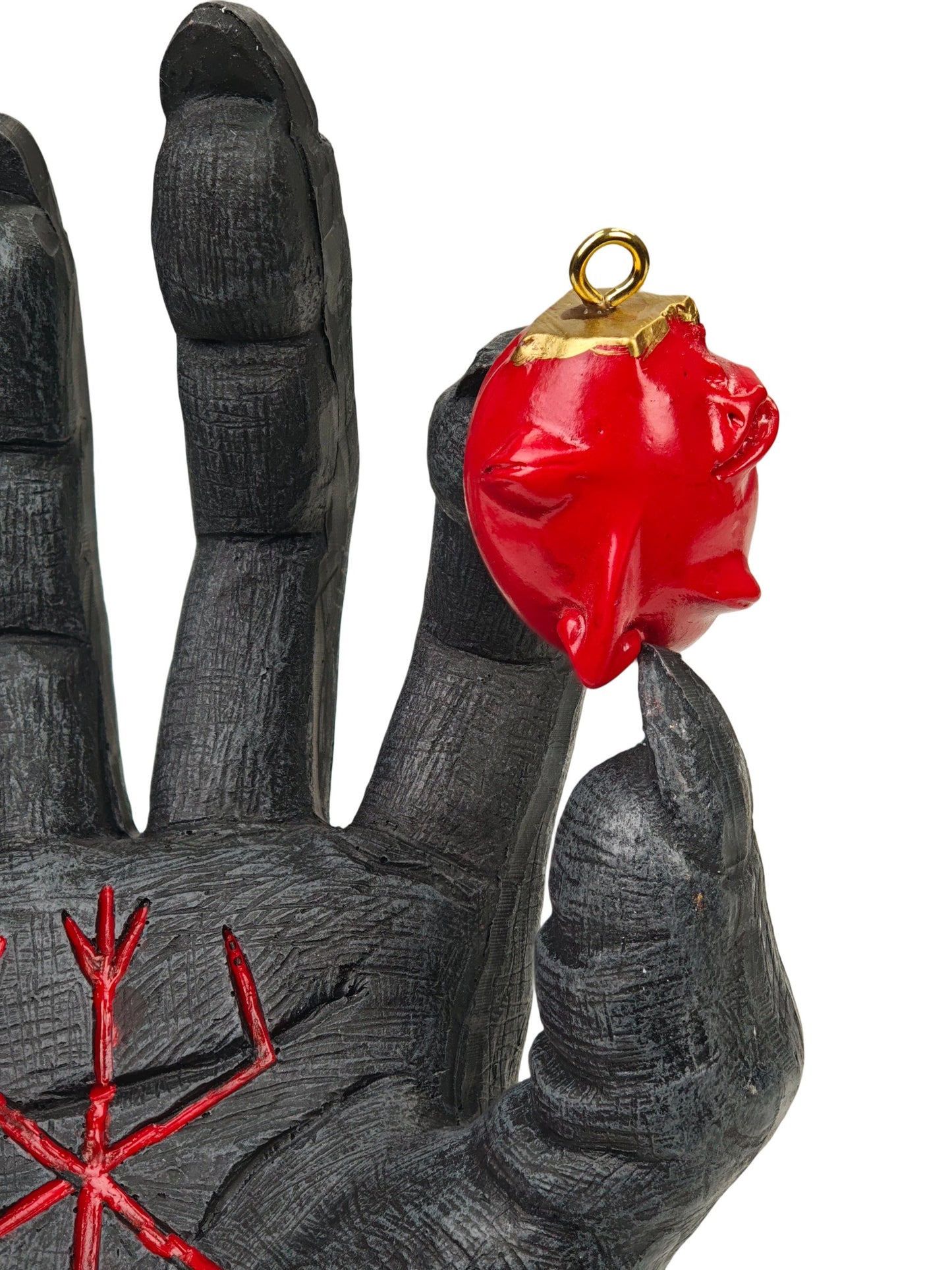 A gothic horror figurine depicting a dark gray skeletal hand with red runes pressing down on a pile of red skulls, set on a cracked dark gray base against a white background.