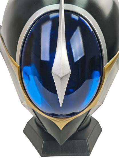 Close-up of Lelouch Zero helmet visor with silver center crest, dark blue acrylic, gold trim, and black base