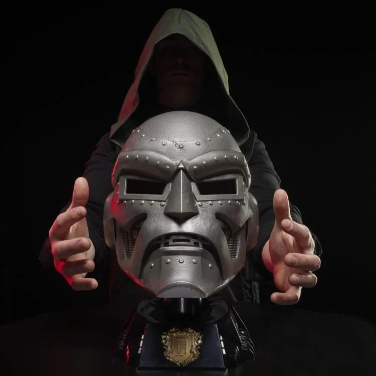 Doctor Doom helmet on display stand with hooded wearer in background