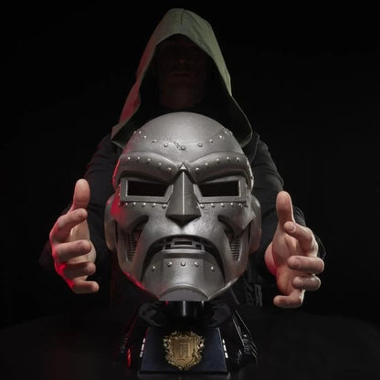 Doctor Doom helmet on display stand with hooded wearer in background