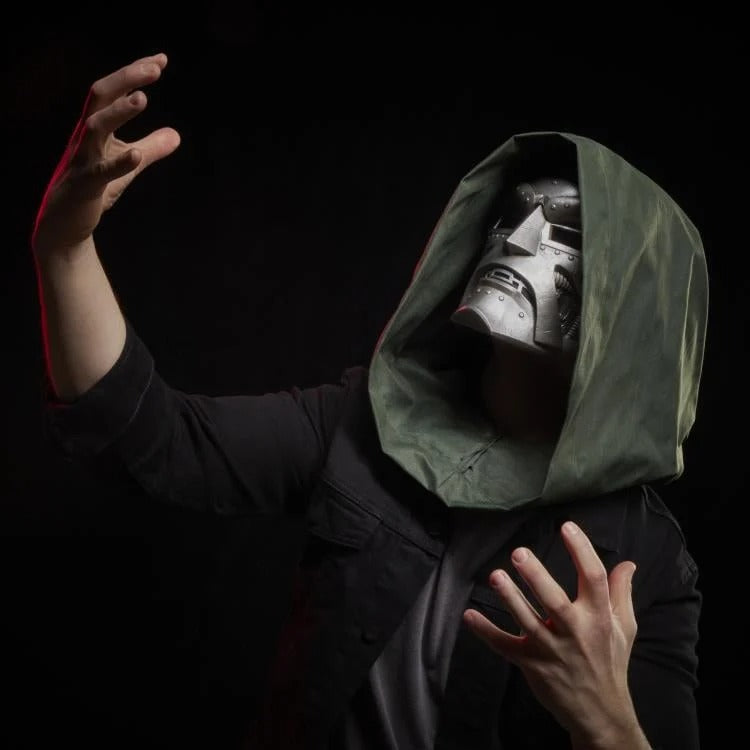 Cosplayer wearing Doctor Doom helmet with green hood in a dramatic pose