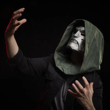 Cosplayer wearing Doctor Doom helmet with green hood in a dramatic pose