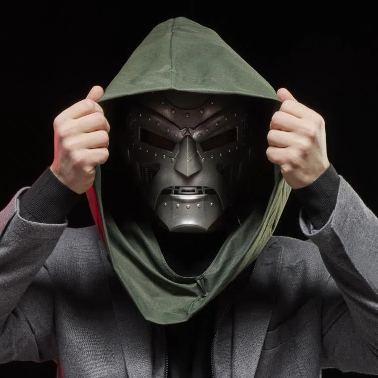 Cosplayer adjusting green hood over Doctor Doom helmet