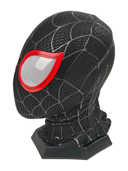 Miles Morales black Spider-Man mask side view with red lens frame, raised web pattern, and black display stand