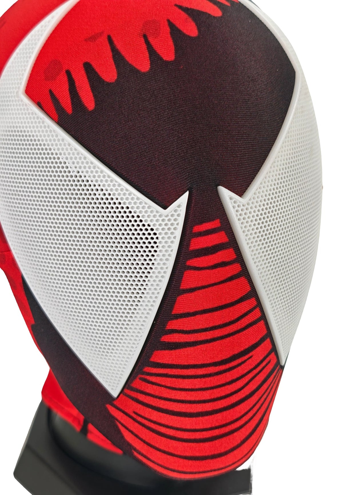 Close-up of Scarlet Spider-Man mask front showing white perforated eye lenses and striped red chin detail