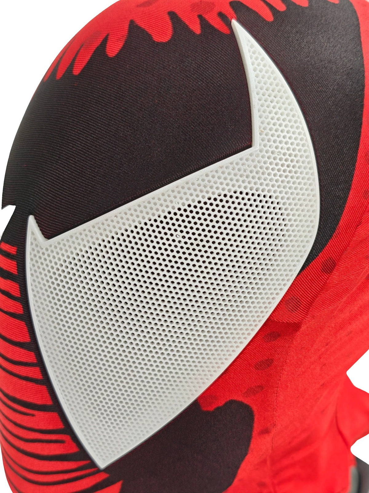 Close-up of Scarlet Spider-Man mask white perforated eye lens with red-and-black patterned fabric