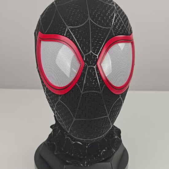 Miles Morales black Spider-Man mask video preview with red eye frames, white mesh lenses, raised web pattern, and stand