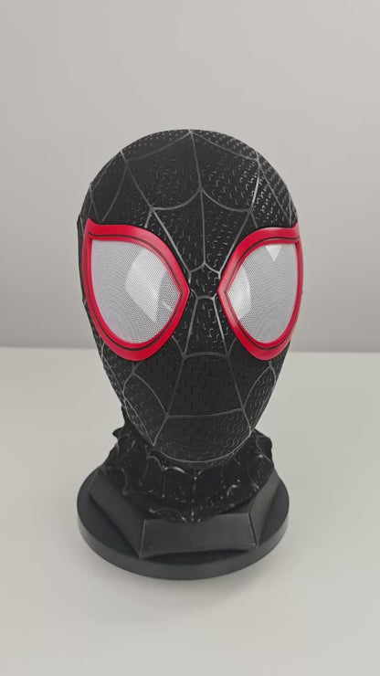 Miles Morales black Spider-Man mask video preview with red eye frames, white mesh lenses, raised web pattern, and stand